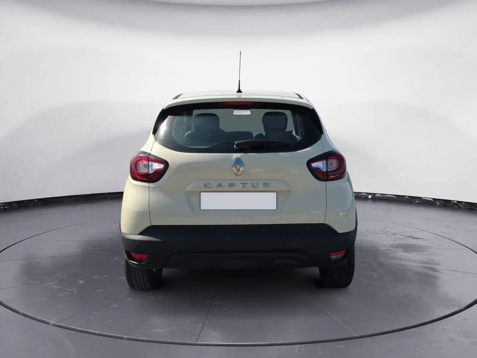 Vue arrière d'un Renault Captur ivoire 2018 avec feux rouges et logo Renault bien visibles.