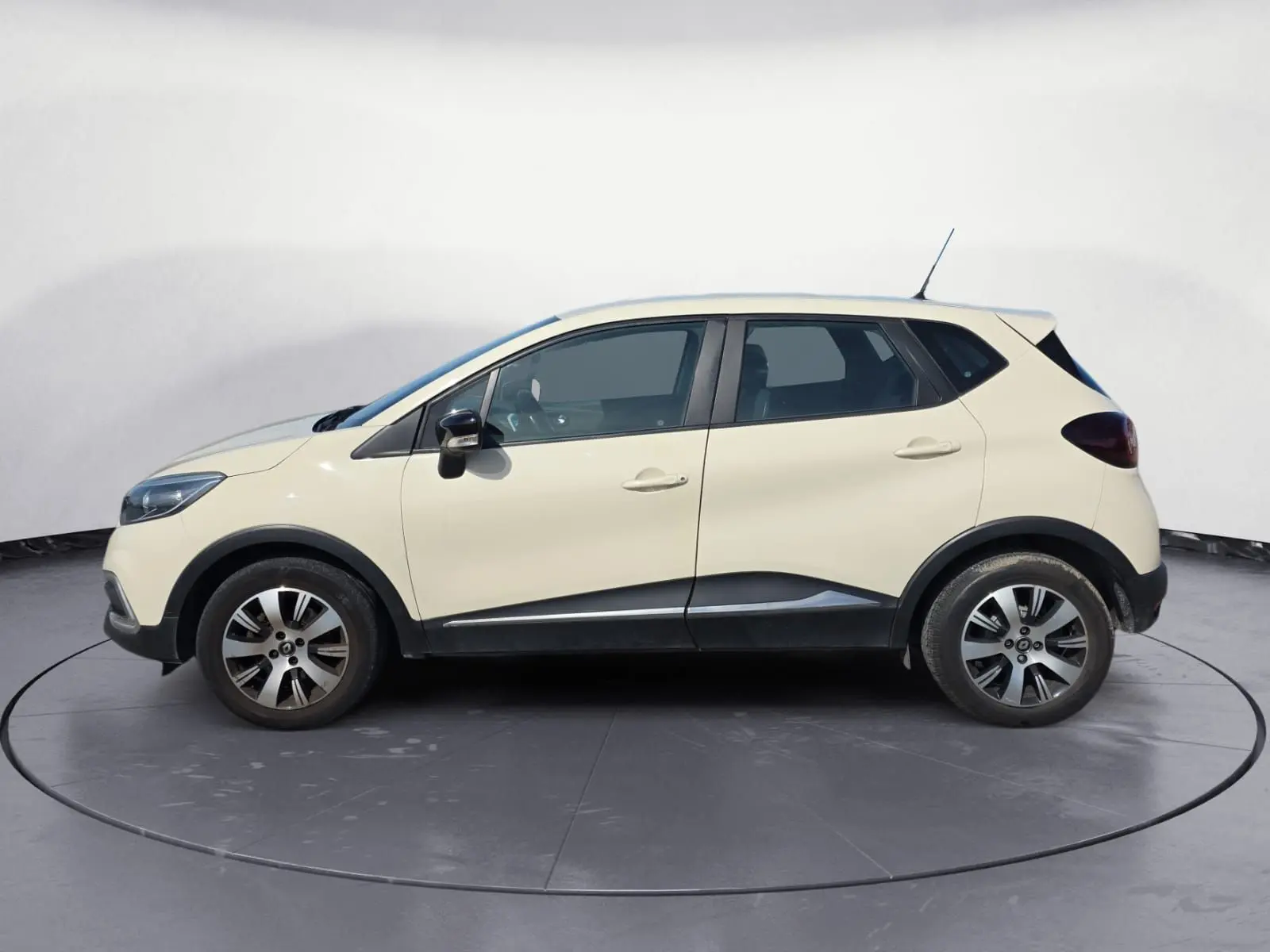 Renault Captur 1.5 DCI 90 Business ivoire vu de profil côté gauche avec jantes alliage et protections noires.