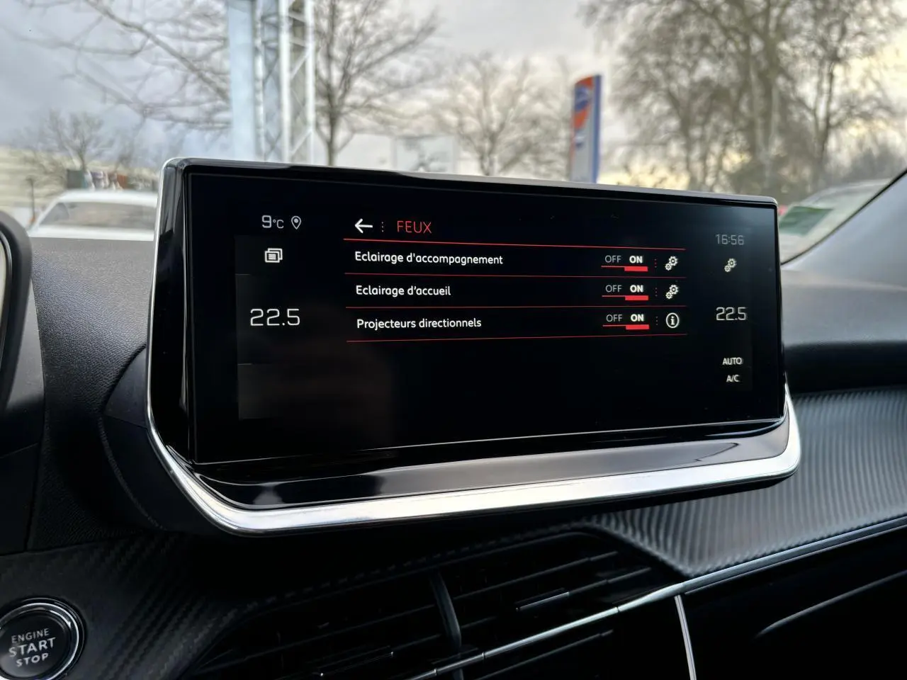 Écran tactile central du Peugeot 2008 2021 affichant les réglages des feux, avec tableau de bord noir et détails chromés.