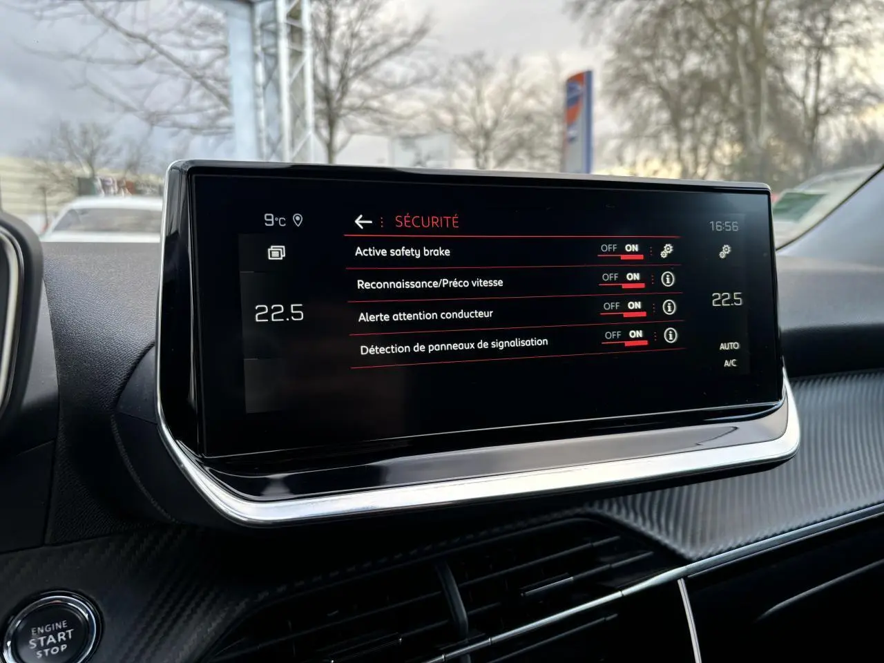 Écran tactile central du Peugeot 2008 2021 affichant les options de sécurité, avec tableau de bord noir et détails carbone.