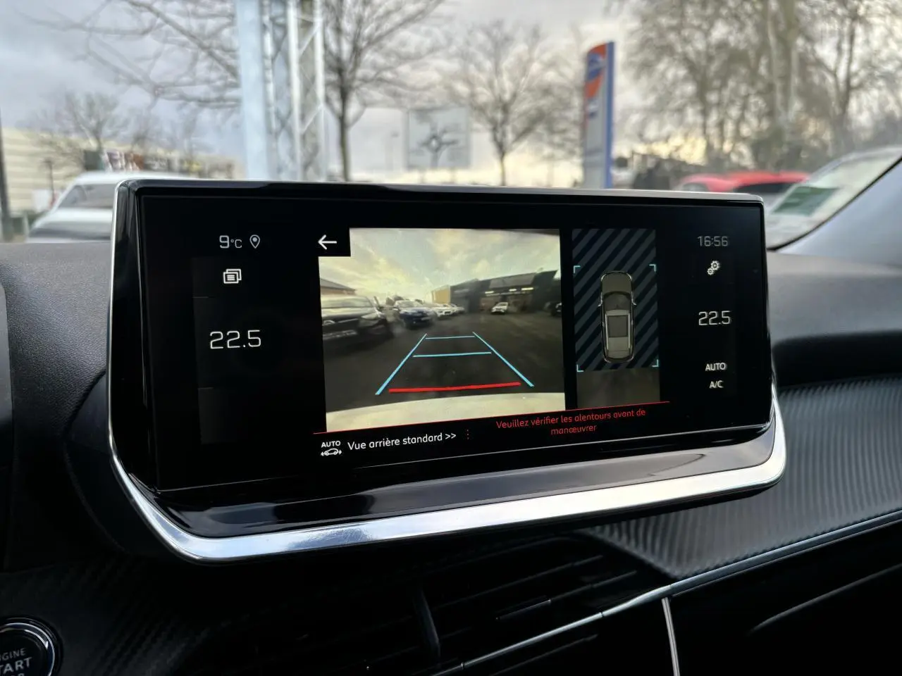 Écran tactile intérieur du Peugeot 2008 affichant la caméra de recul et l'aide au stationnement en journée.