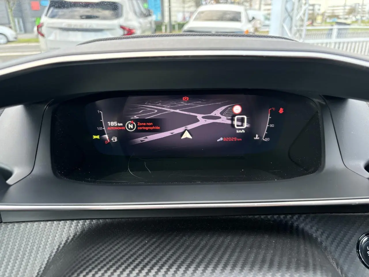 Affichage numérique du combiné Peugeot 2008 2021 avec navigation et indicateurs de vitesse et autonomie.