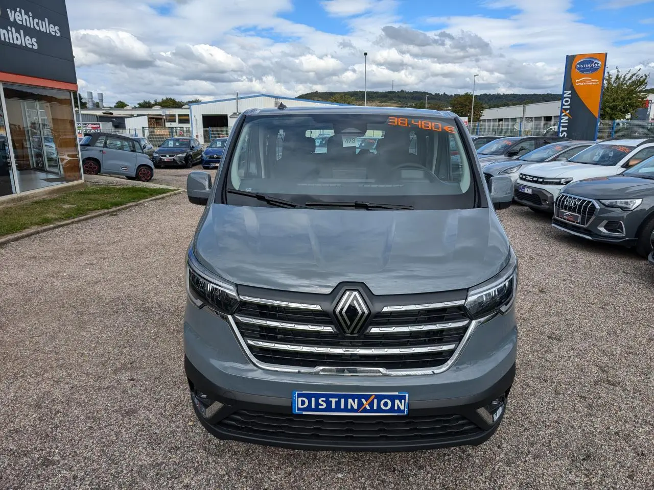 Vue frontale d'un Renault Trafic Fourgon gris 2024 avec calandre chromée et logo Renault bien visible.