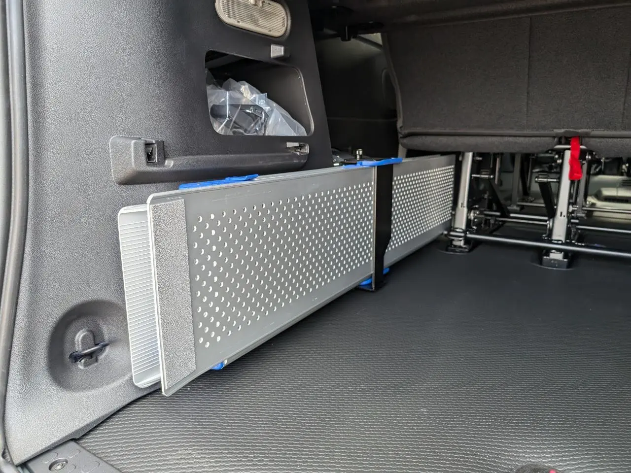 Détail intérieur montrant la rampe amovible en aluminium ajouré du Renault Trafic Fourgon gris, version 2024.
