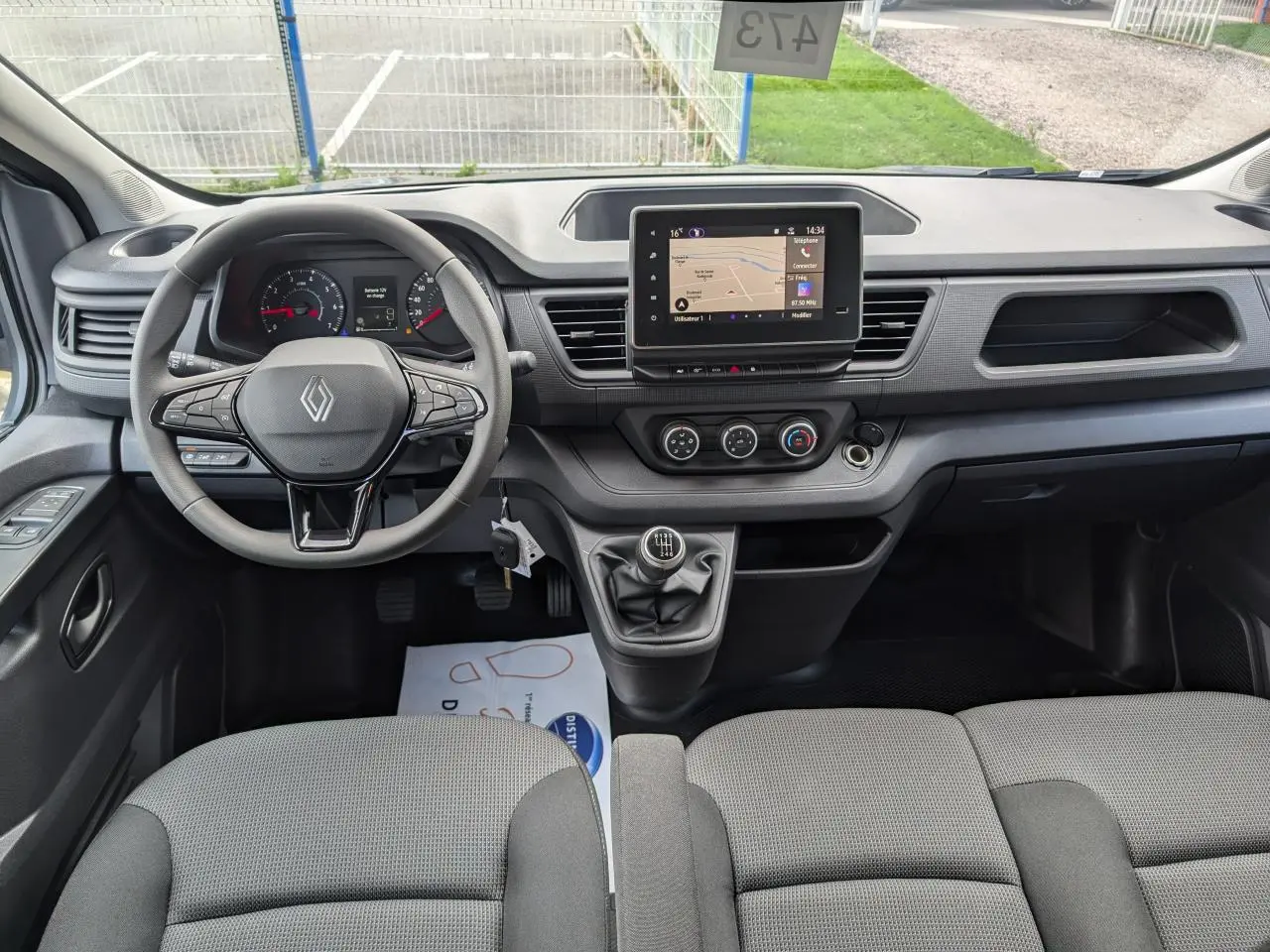 Vue intérieure avant du Renault Trafic Fourgon 2024 avec tableau de bord moderne et écran tactile central.