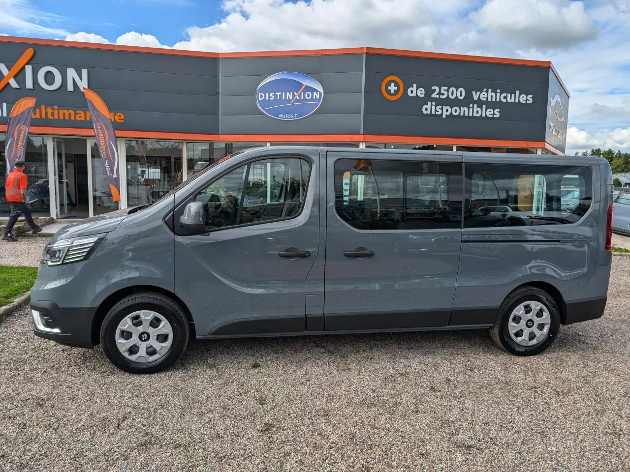 Profil côté gauche du Renault Trafic Fourgon gris 2024 avec vitres latérales et jantes en alliage visibles.