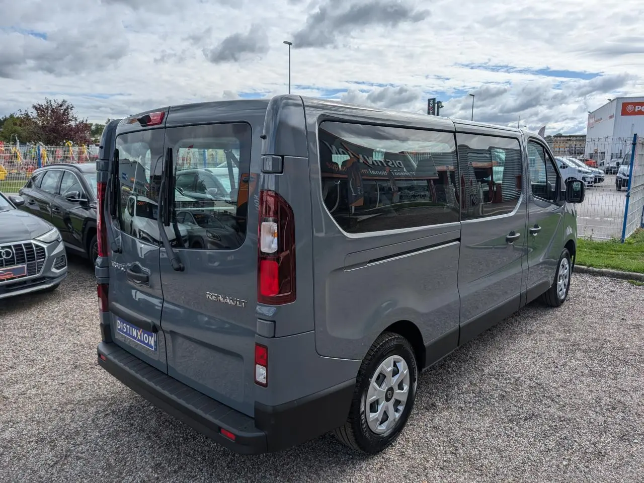 Renault Trafic Fourgon gris Urban vu en 3/4 arrière droit avec vitres latérales et hayon vitré
