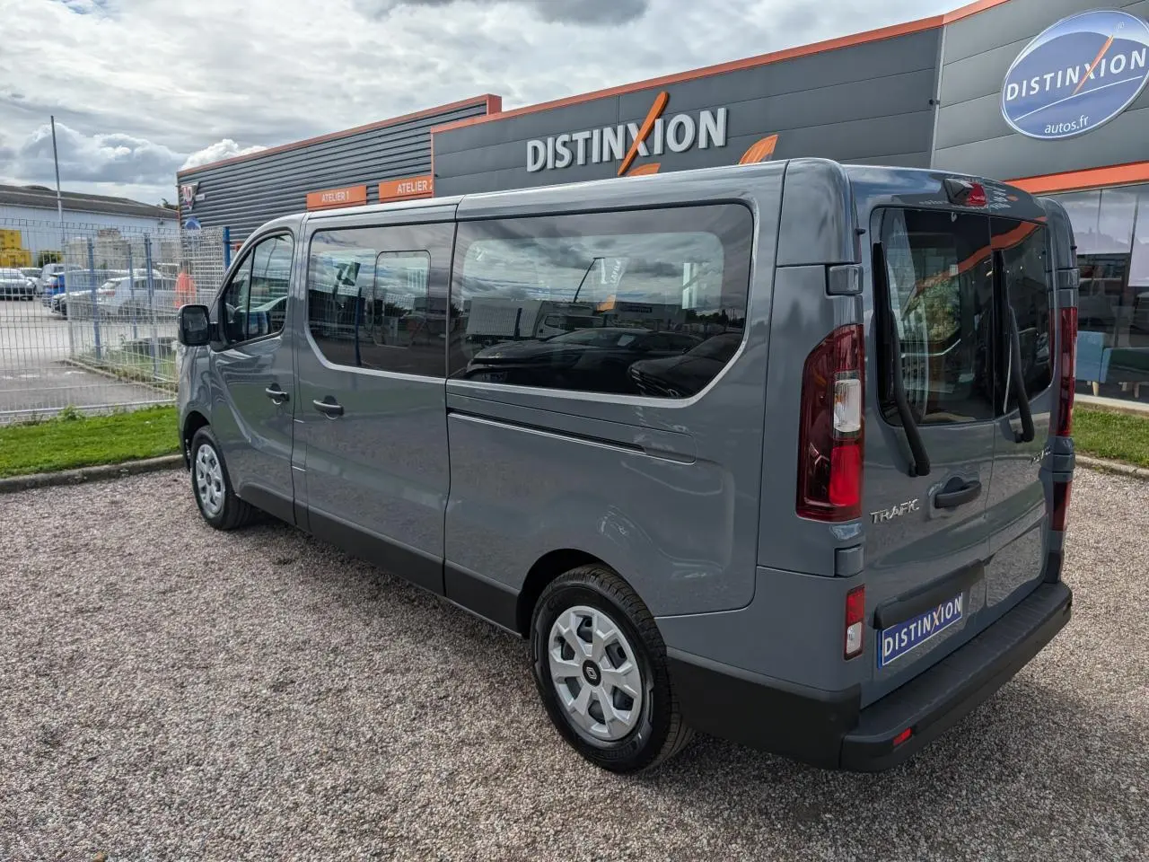 Renault Trafic Fourgon gris Urban en vue 3/4 arrière droit, avec vitres latérales et jantes à enjoliveurs.