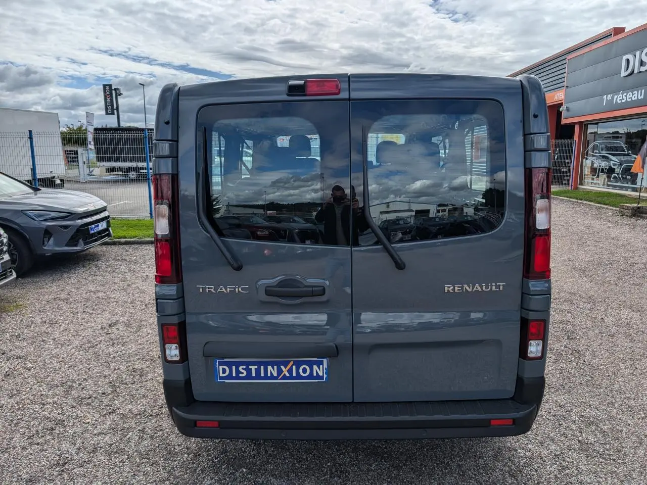 Vue arrière du Renault Trafic Fourgon gris avec portes vitrées et essuie-glaces sur chaque vantail.