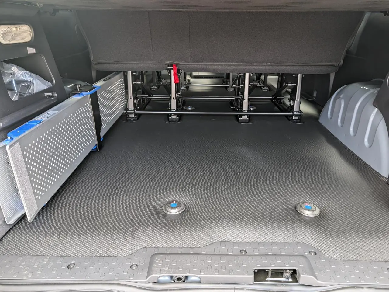 Espace de chargement arrière du Renault Trafic Fourgon gris 2024 avec rampe amovible Easy Access sur le côté gauche.