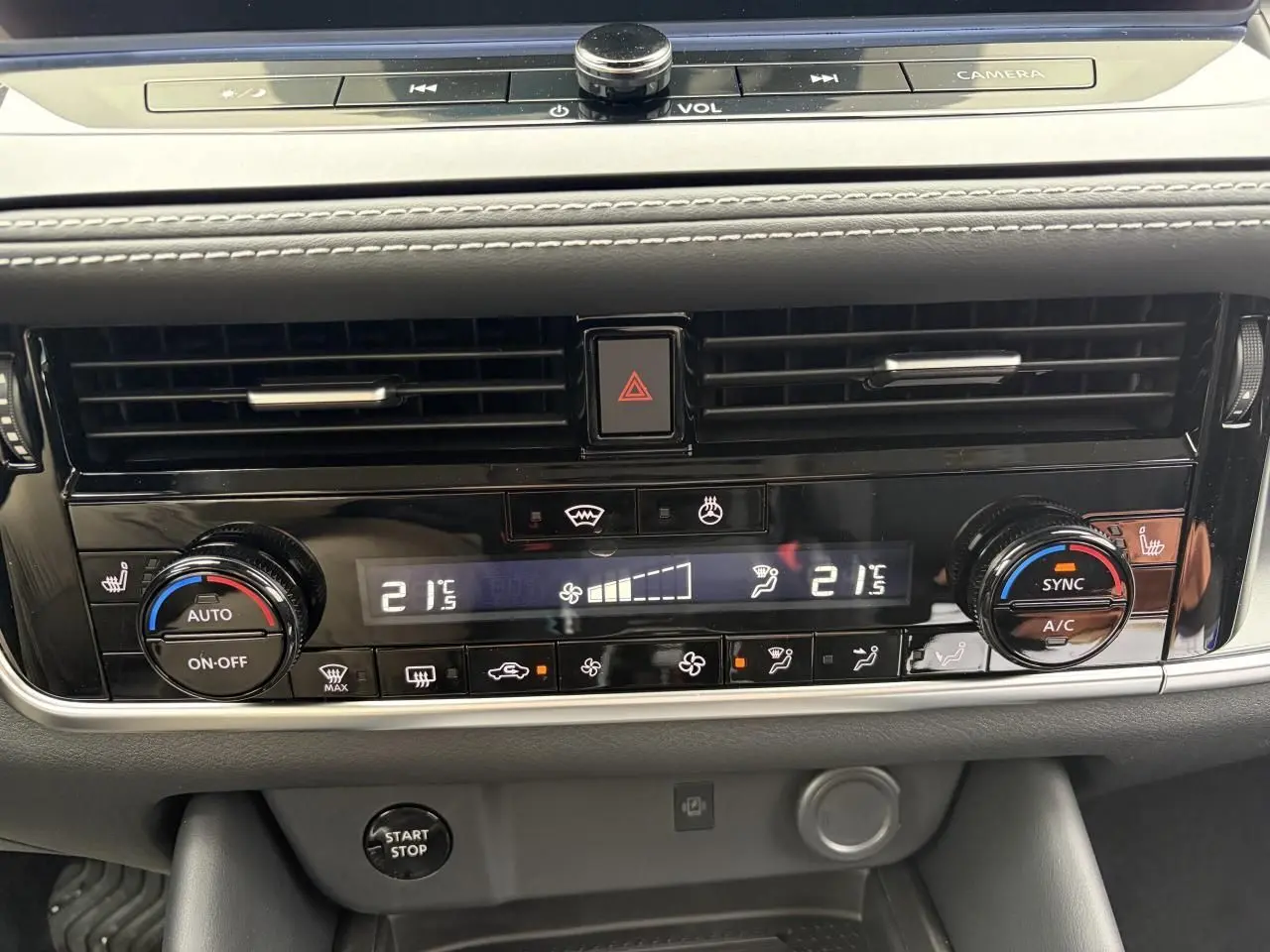 Gros plan sur la console centrale du Nissan Qashqai 2025, affichage digital de la climatisation bi-zone et commandes tactiles.