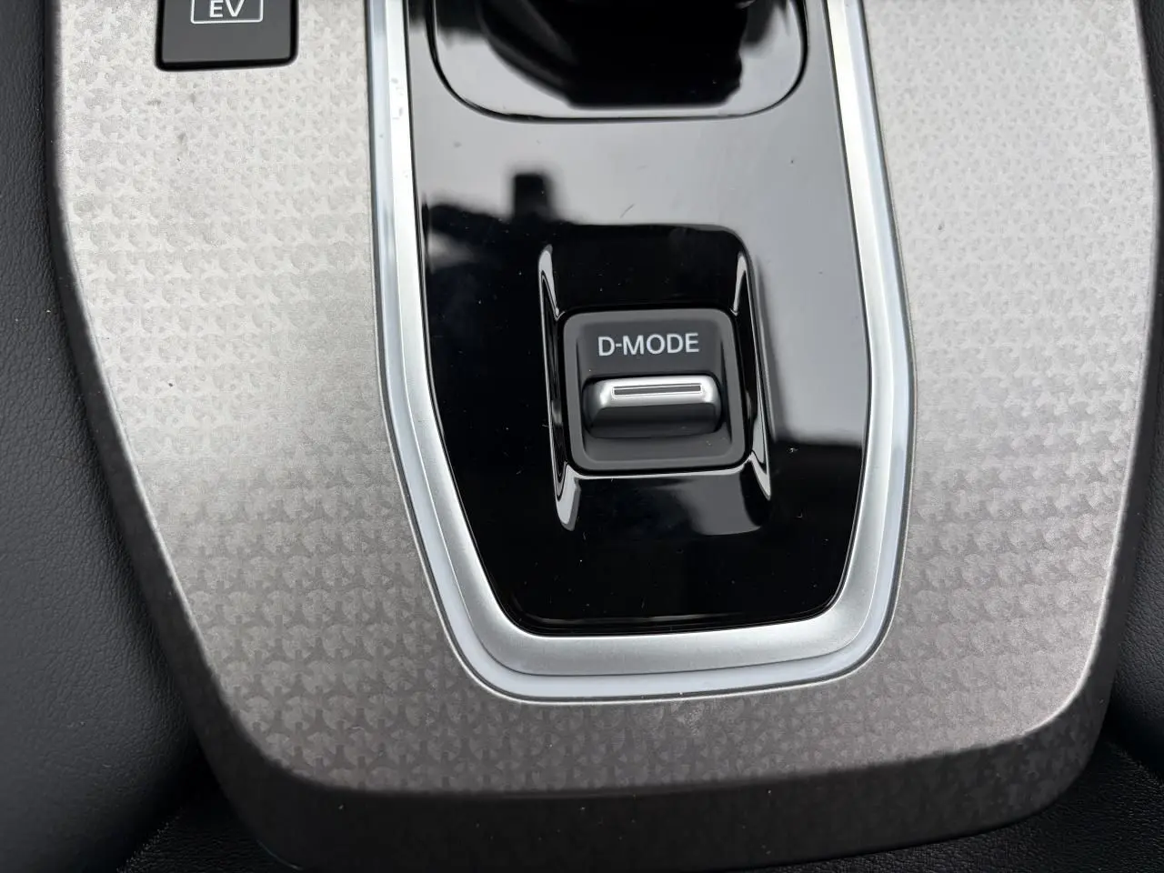 Gros plan sur la console centrale grise avec bouton D-MODE du Nissan Qashqai III 1.5 Hybrid E-Power 2025.