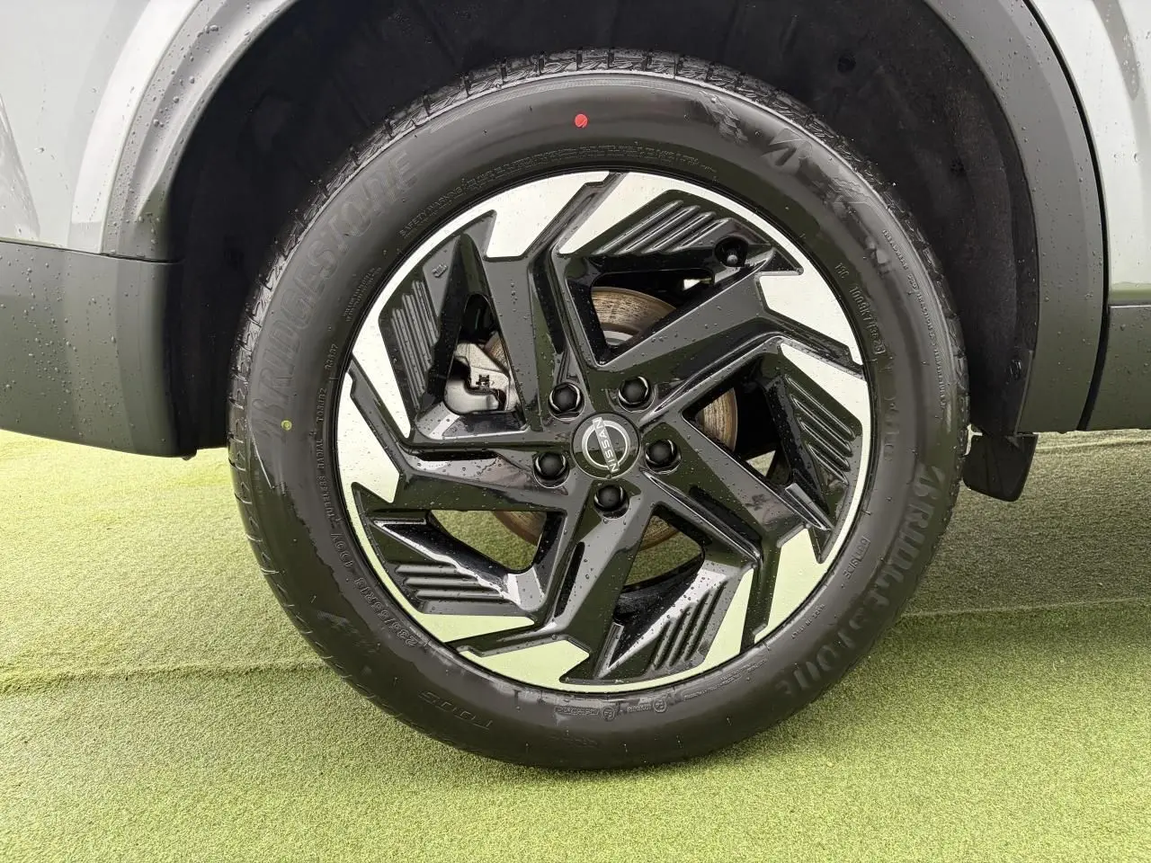 Gros plan sur la jante alliage 18 pouces bicolore noir et argent du Nissan Qashqai III gris foncé.