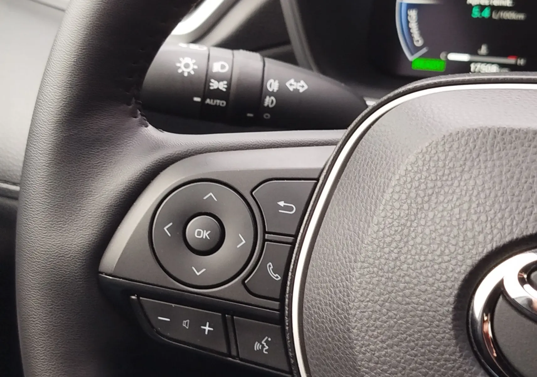 Gros plan sur la partie gauche du volant noir du Toyota Corolla Cross 2025, avec commandes multifonctions visibles.