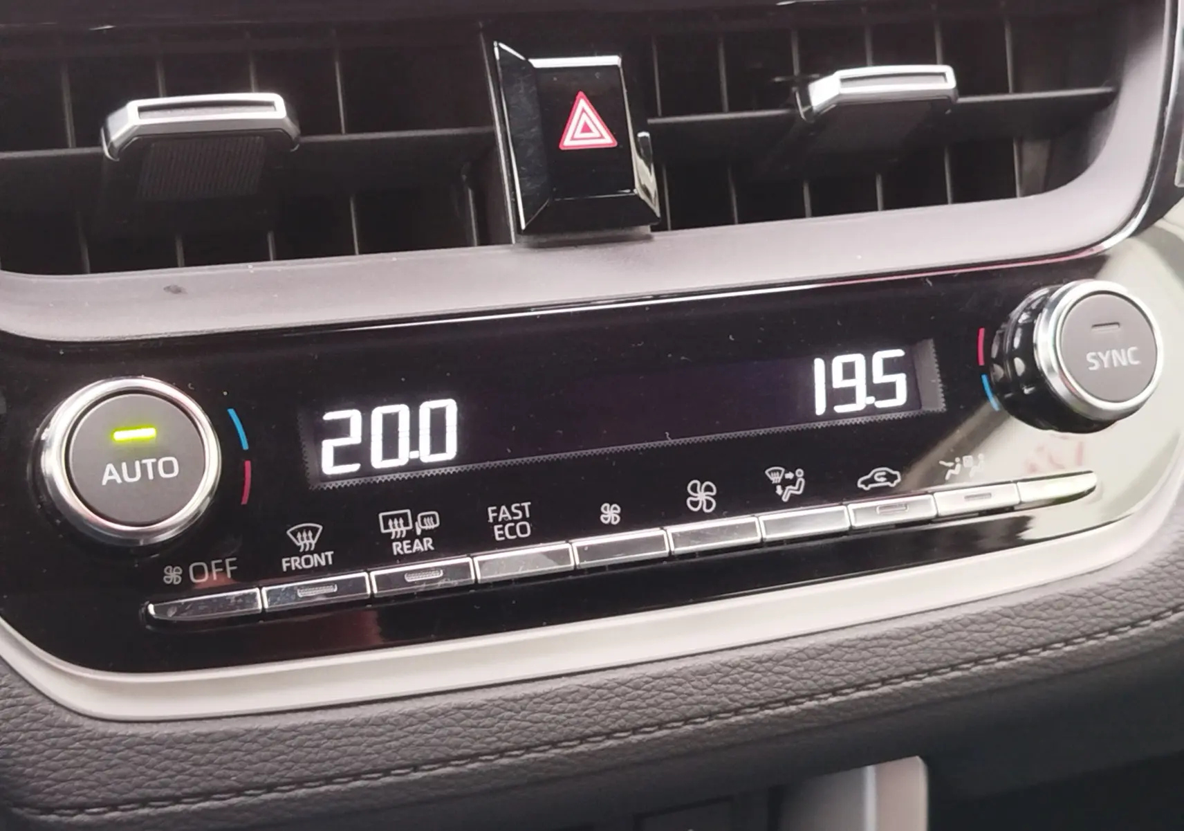 Vue rapprochée du tableau de bord de la Toyota Corolla Cross 2025, affichant la climatisation digitale avec réglages à 20 et 19,5 degrés.