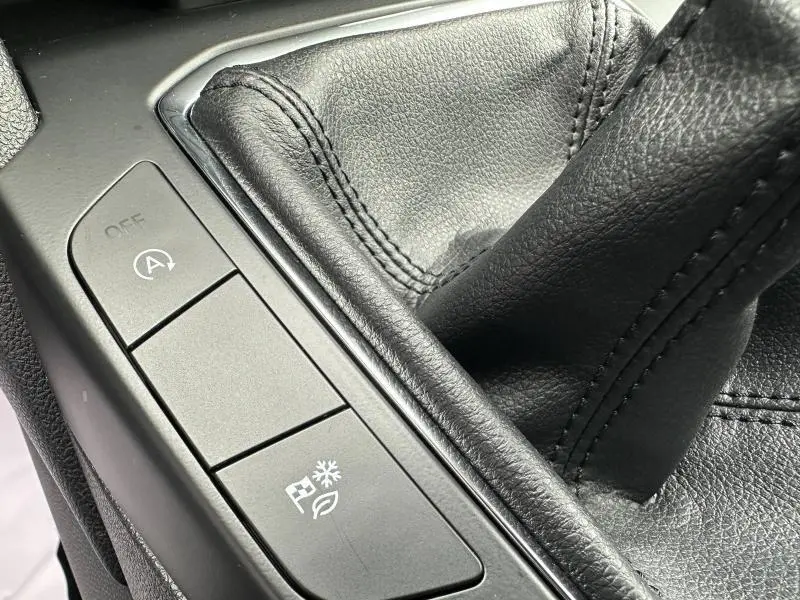 Gros plan sur la console centrale noire du Ford Kuga 2024, montrant le levier de vitesse manuel et les boutons de contrôle.