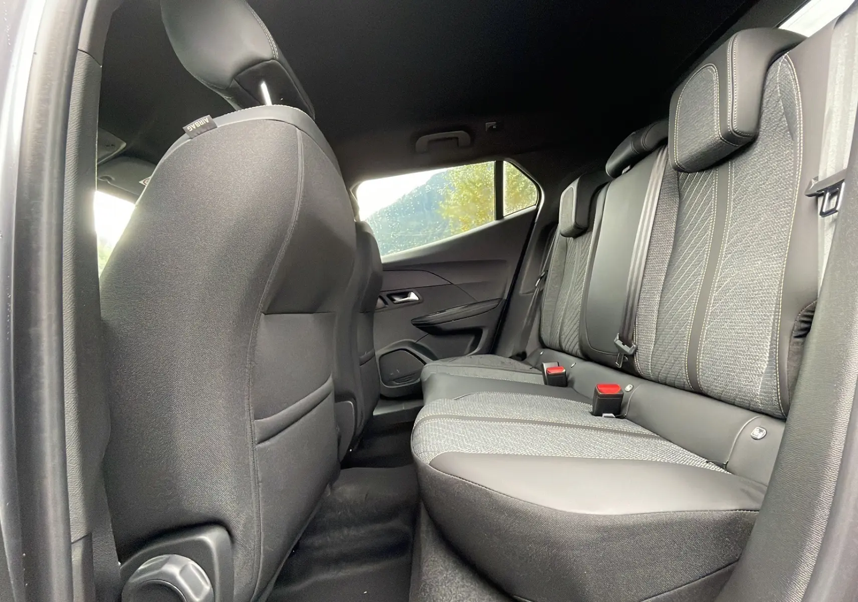 Vue intérieure arrière droite des sièges arrière gris et tissu du Peugeot 2008 2024 version Allure Grip Visio2.