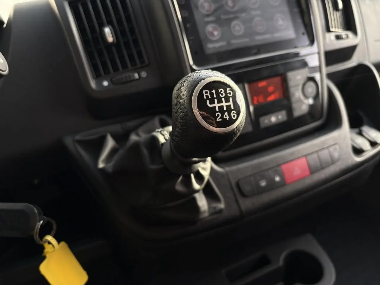 Gros plan sur le levier de vitesses manuel noir du tableau de bord d’un Opel Movano Fourgon blanc, 2024.