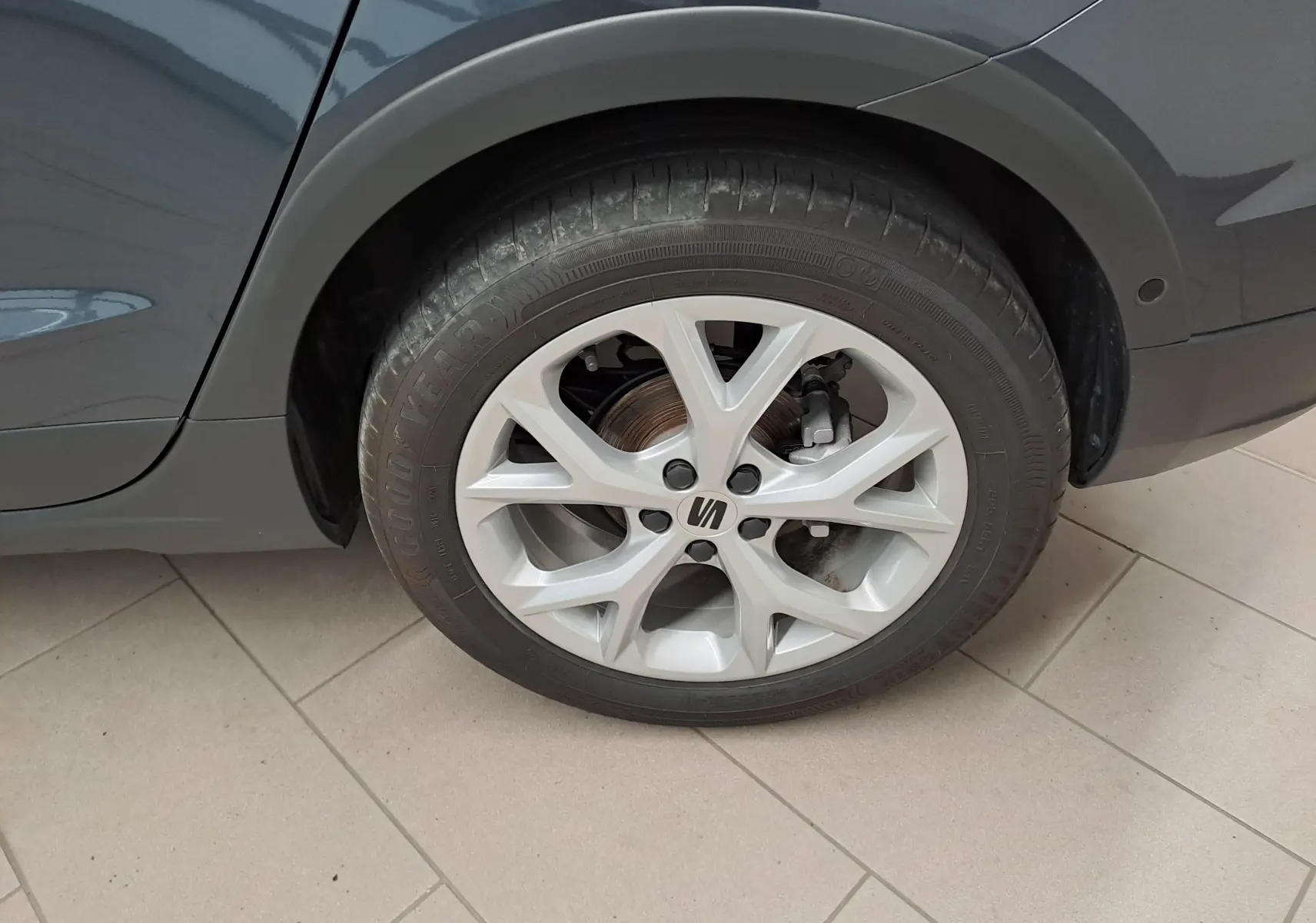 Gros plan sur la roue arrière droite du SEAT Arona gris magnétique avec jante alliage 18 pouces et logo central.