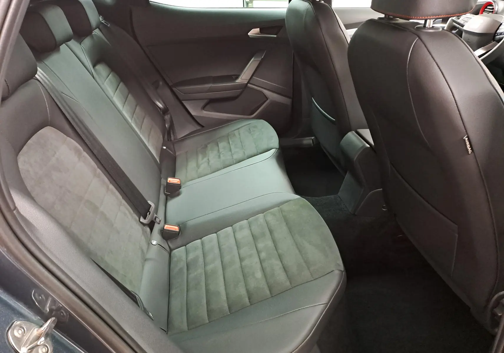 Vue intérieure côté arrière droit du SEAT Arona 2024, montrant les sièges arrière en tissu noir avec surpiqûres.