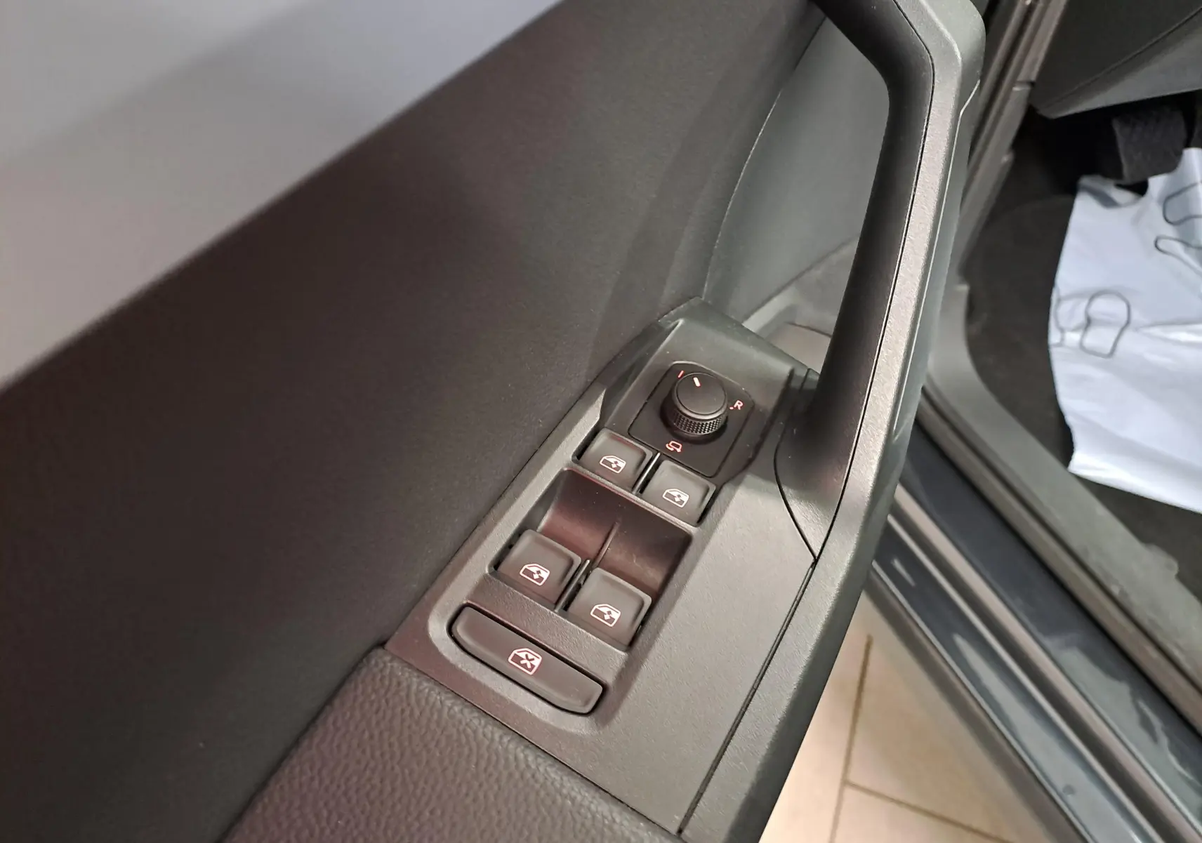 Gros plan sur les commandes des vitres et rétroviseurs côté conducteur du SEAT Arona 2024, intérieur noir.