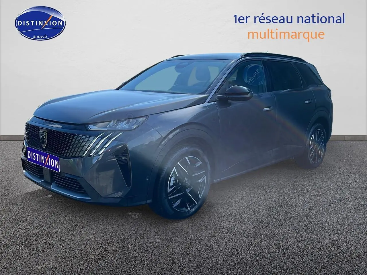 Peugeot 5008 gris titane en 3/4 avant droit, avec calandre distinctive et jantes alliage noires.