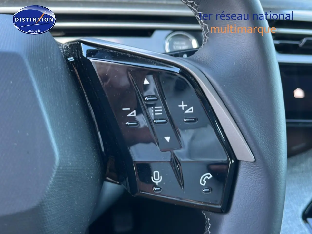 Gros plan sur les commandes vocales et audio au volant cuir du Peugeot 5008 Hybrid 145 allure gris titane, côté gauche.