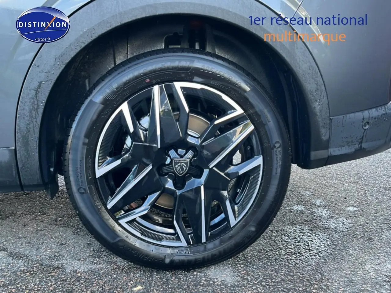 Gros plan sur la roue avant gauche avec jante alu noire et grise du Peugeot 5008 gris titane.