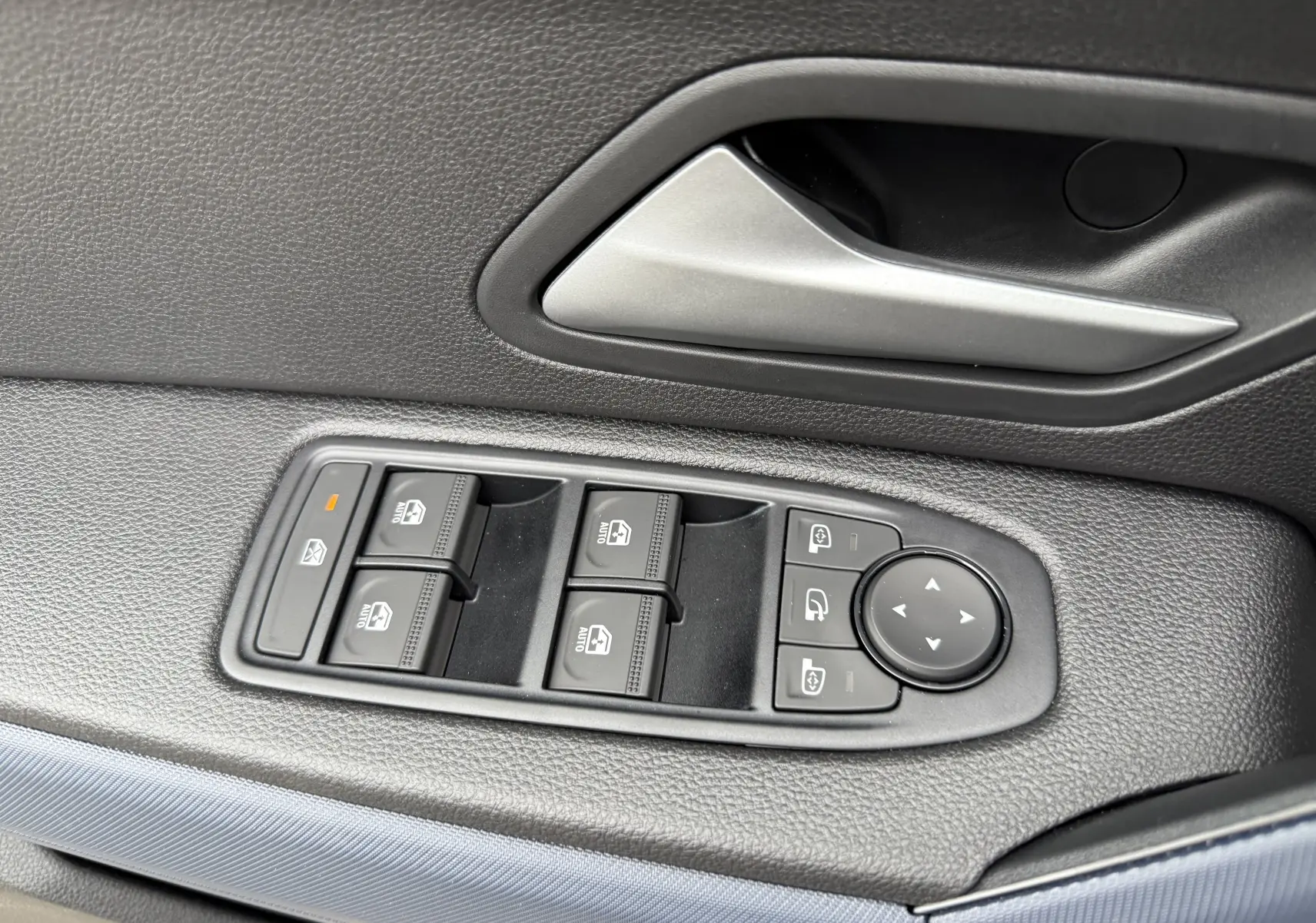 Panneau de commandes des vitres et rétroviseurs côté gauche intérieur du Dacia Duster 1.6 Hybrid gris schiste 2025.
