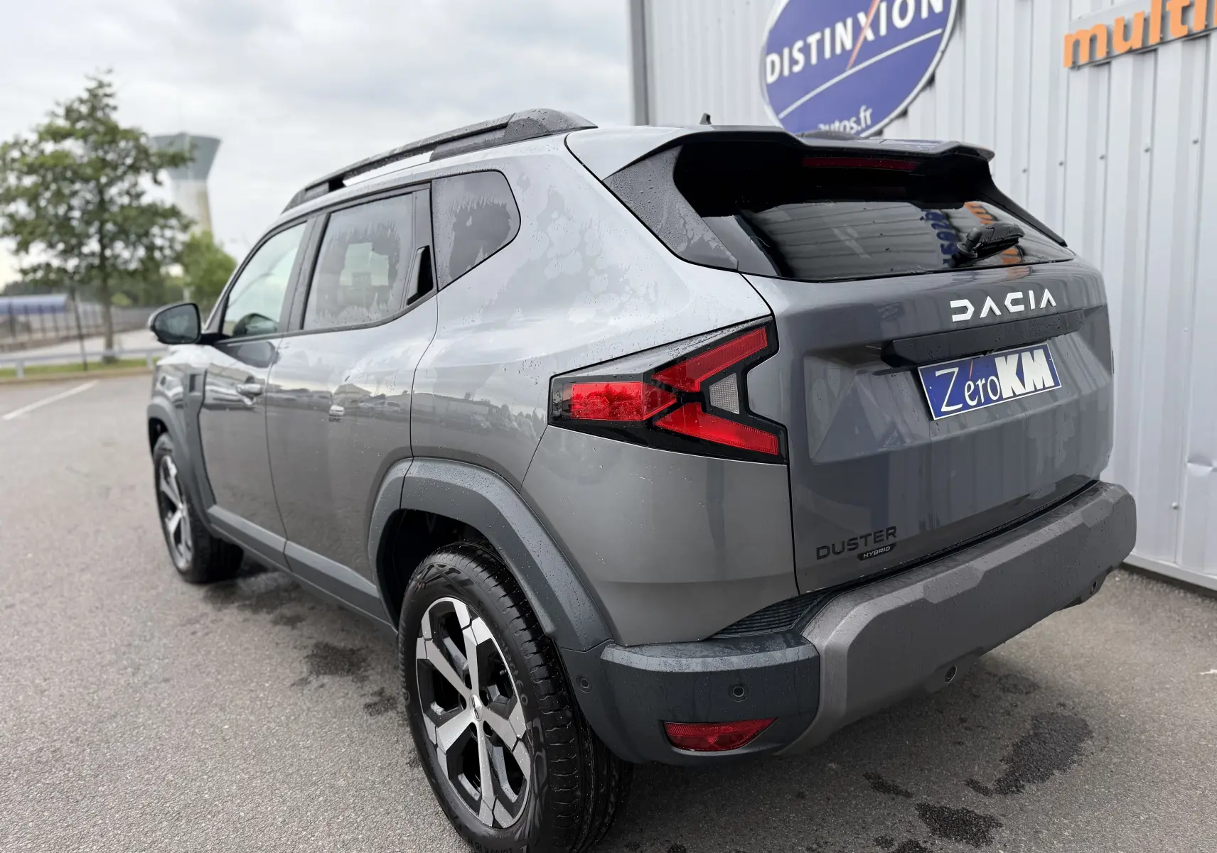 Vue 3/4 arrière droite du Dacia Duster 2025 gris schiste avec feux arrière LED et jantes alliage noires.