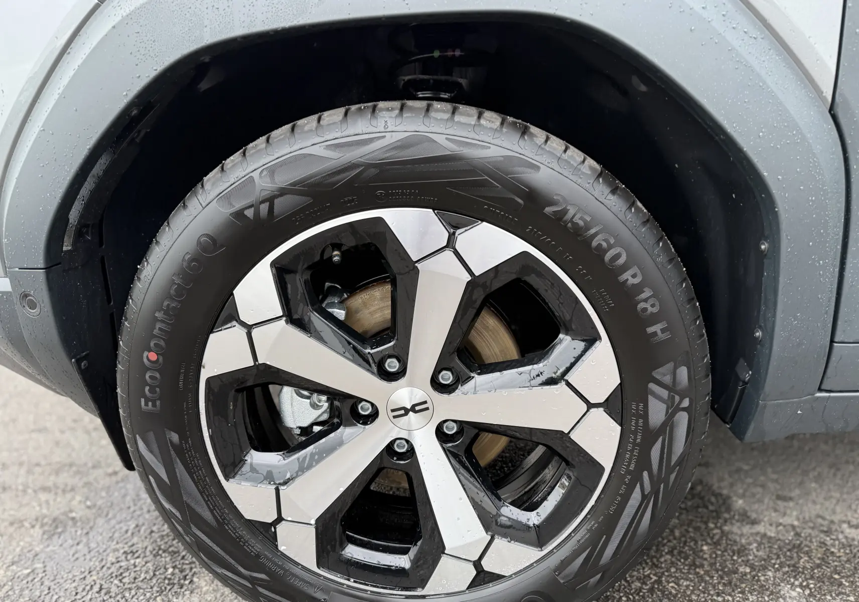 Gros plan sur la roue avant gauche du Dacia Duster gris schiste 2025 avec jante alliage noire et argentée au design géométrique.