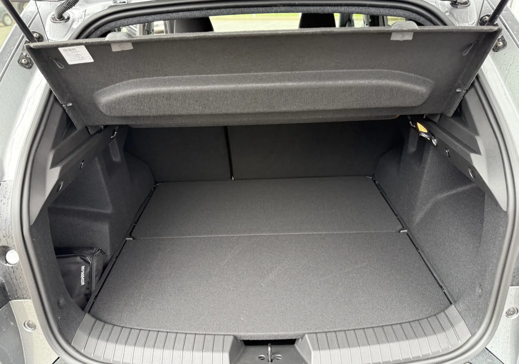 Coffre ouvert du Dacia Duster gris schiste 2025, montrant un espace de chargement propre et spacieux.