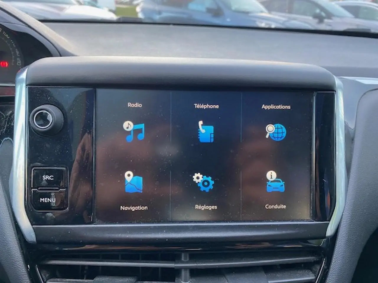 Écran tactile central de la Peugeot 208 gris 2017 affichant les menus radio, téléphone, navigation et réglages.