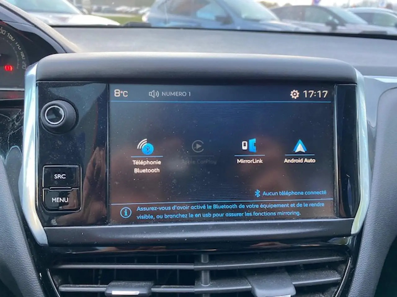 Écran tactile central de la Peugeot 208 gris de 2017 affichant les options Bluetooth et MirrorLink en intérieur.