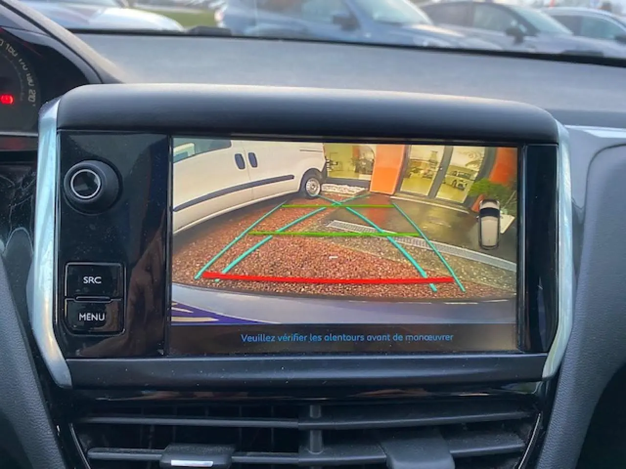 Écran tactile de la Peugeot 208 gris montrant la caméra de recul avec lignes de guidage en arrière-plan.