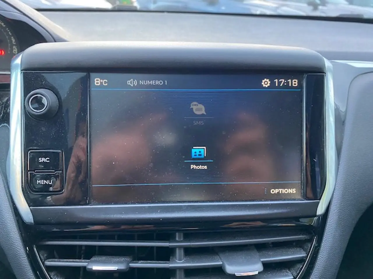 Écran tactile central du tableau de bord de la Peugeot 208 gris, affichant le menu multimédia avec options photos.