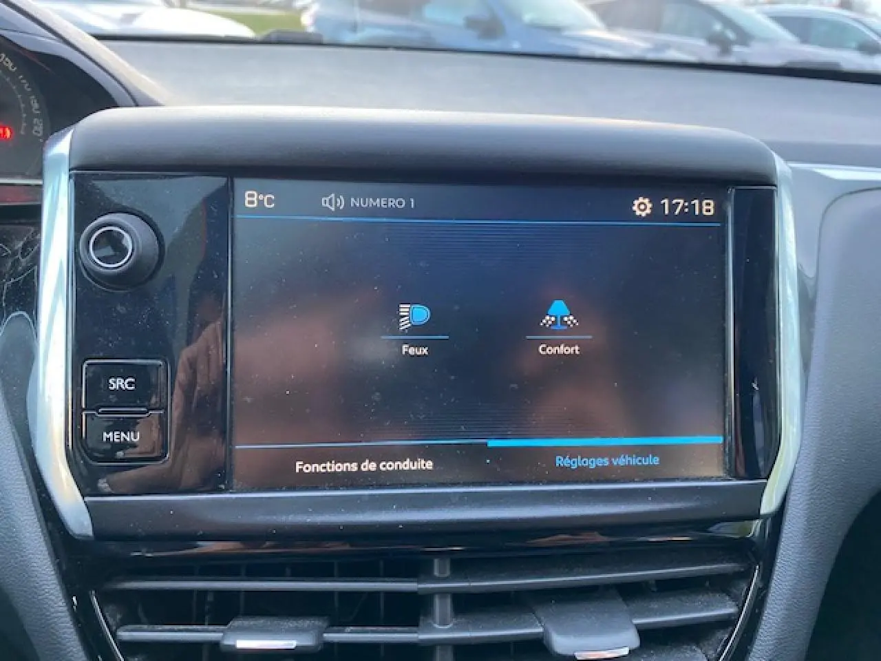 Écran tactile central de la Peugeot 208 gris, affichant les réglages des fonctions de conduite à 17h18.
