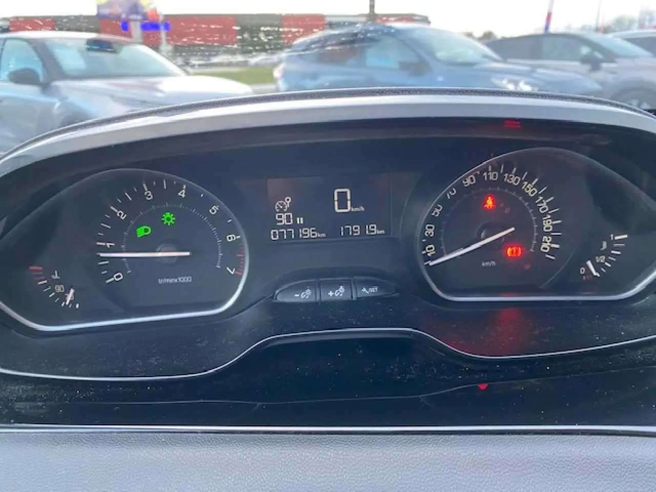 Tableau de bord de Peugeot 208 gris 2017 montrant compte-tours, vitesse à zéro et témoins lumineux allumés.