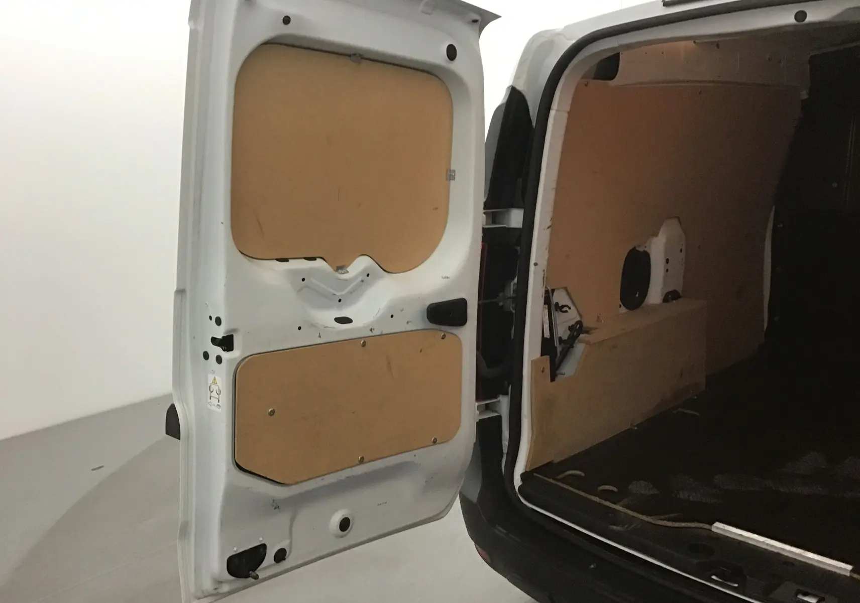 Vue arrière ouverte du Renault Express Van blanc 2023 montrant l'intérieur utilitaire avec panneaux en bois.