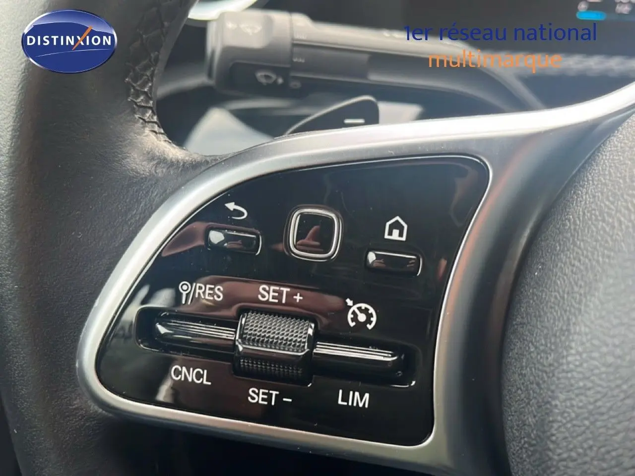 Gros plan sur les commandes de régulateur de vitesse au volant cuir noir d'une Mercedes Classe A 180 Business Line 2020.