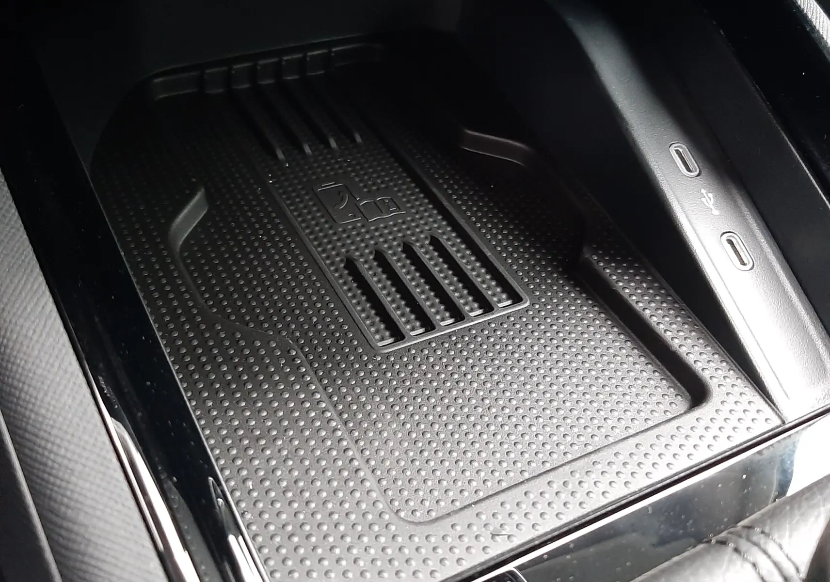 Gros plan sur le chargeur sans fil et les ports USB-C intégrés dans la console centrale du Skoda Kamiq 2025.