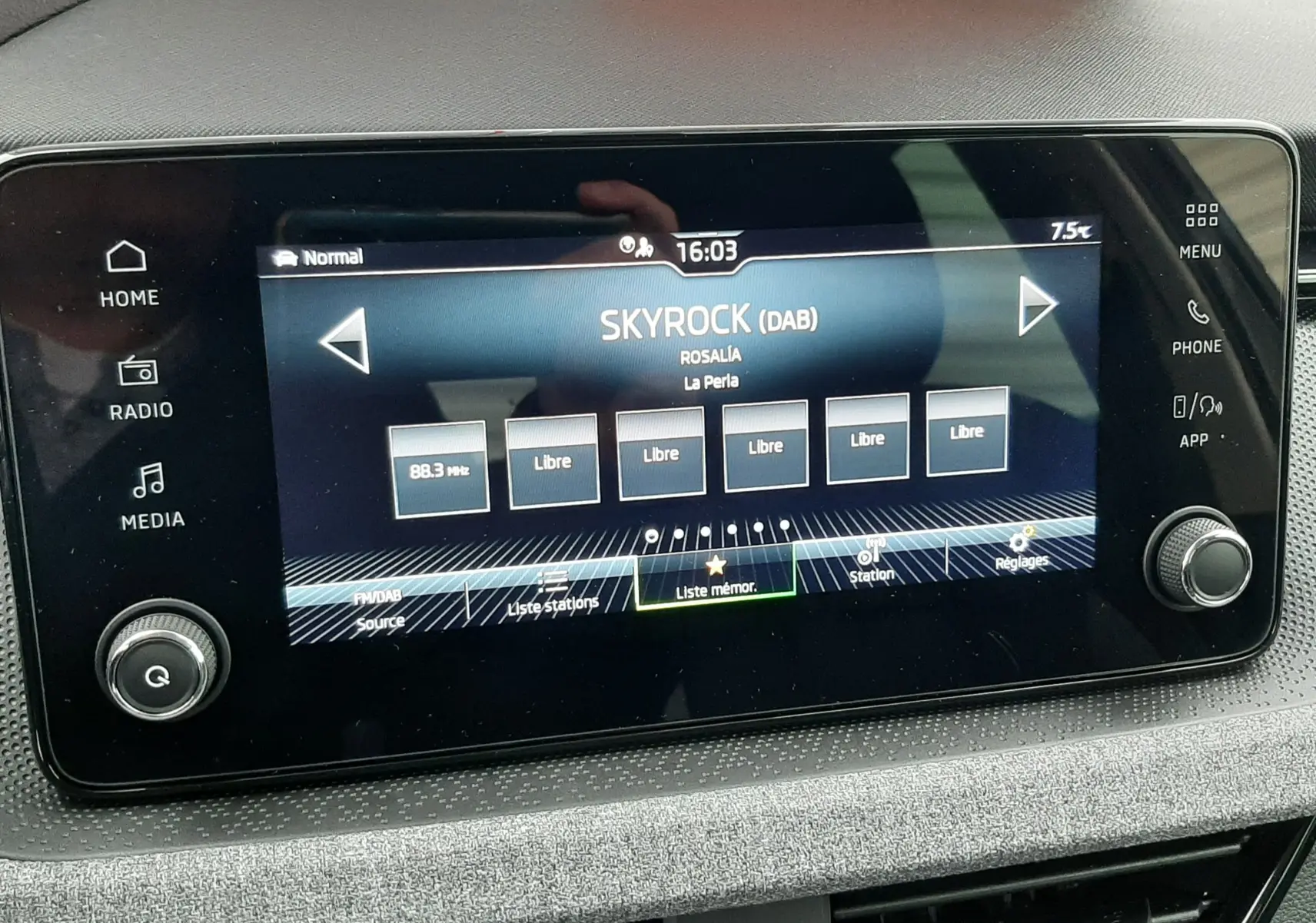 Écran tactile multimédia allumé dans l'habitacle du Skoda Kamiq gris graphite, affichant la radio Skyrock à 16h03.