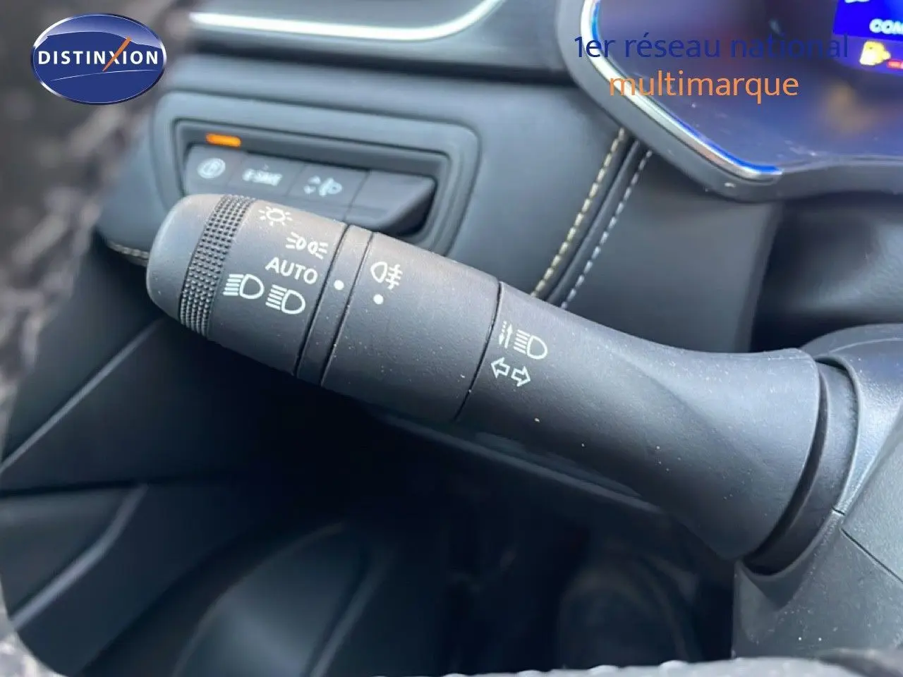 Gros plan sur la commande des feux et clignotants à gauche du volant dans l’habitacle du Renault Symbioz gris Casiopee Metal.