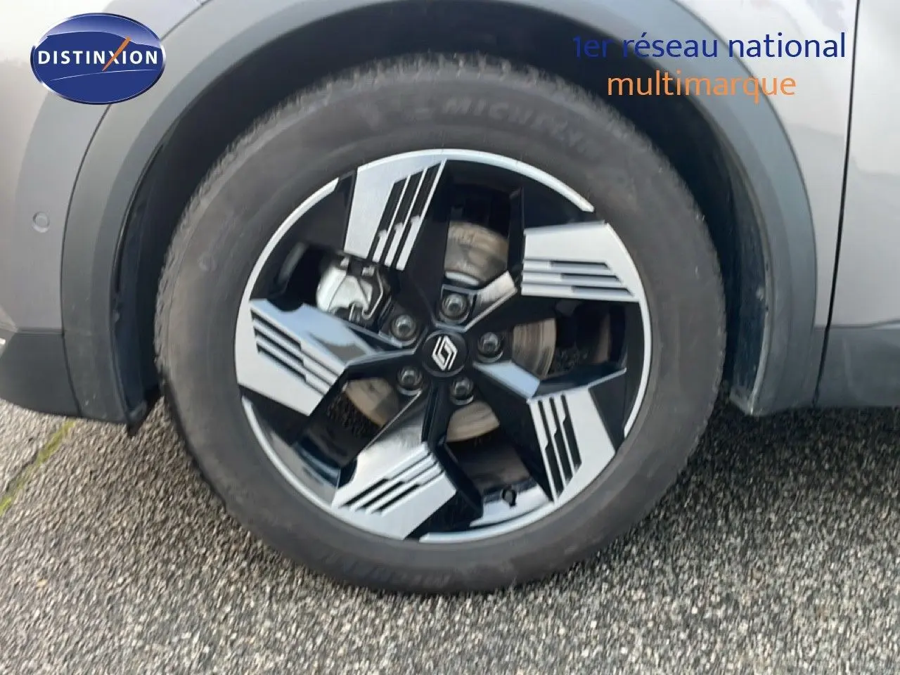 Gros plan sur la roue avant droite avec jante noire et grise du Renault Symbioz gris Casiopee Metal.