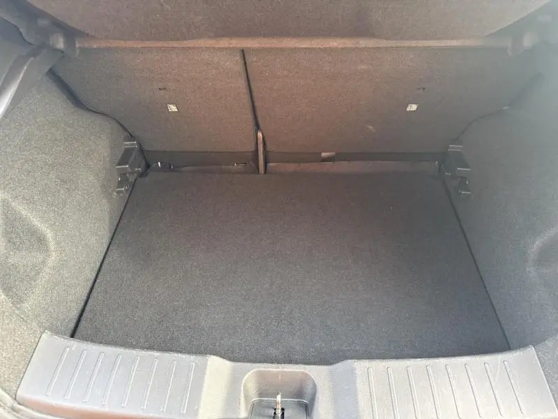 Vue intérieure du coffre spacieux et propre du Nissan Juke 2022, revêtement noir uniforme sans chargement.