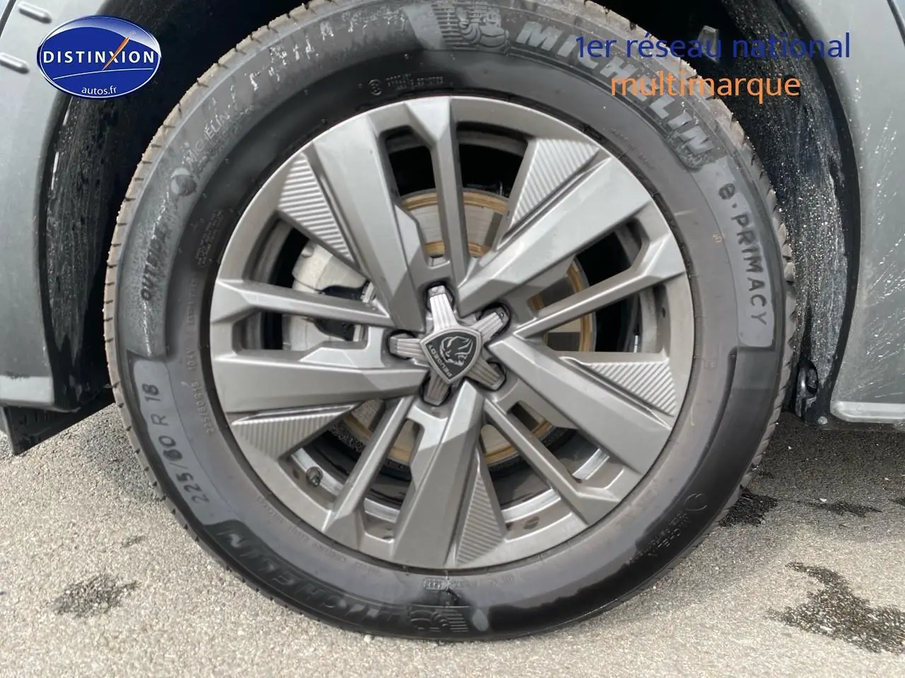 Gros plan sur la jante alu grise et le pneu Michelin d'une Peugeot 5008 noir, côté avant droit.
