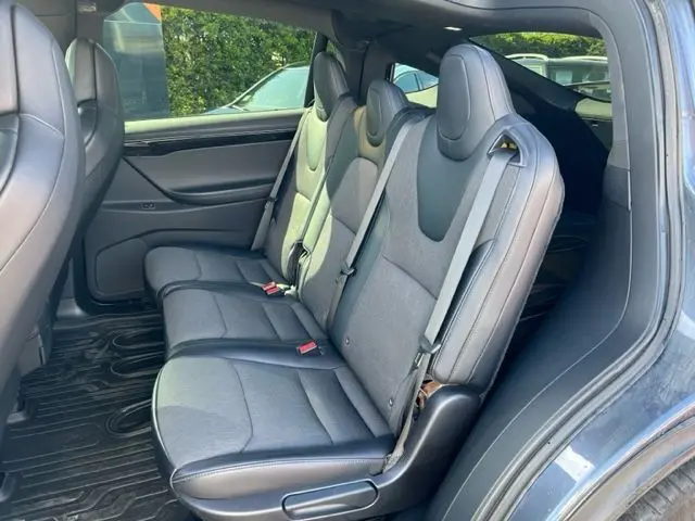 Vue intérieure côté droit des sièges arrière gris du Tesla Model X Standard AWD 2019 avec ceintures de sécurité visibles.