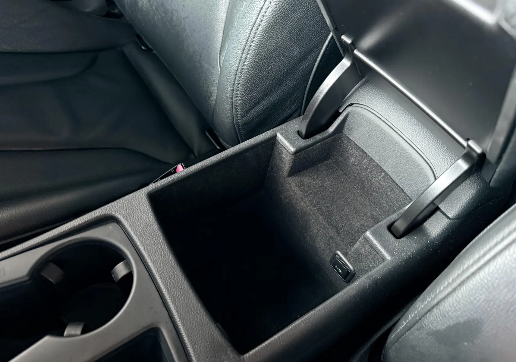 Gros plan sur le rangement central ouvert en cuir noir de l'Audi A5 Sportback 2011, avec prise AUX visible.