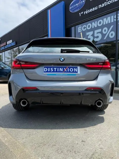 Vue arrière d'une BMW Série 1 118d gris foncé avec double sortie d'échappement et feux LED distinctifs.