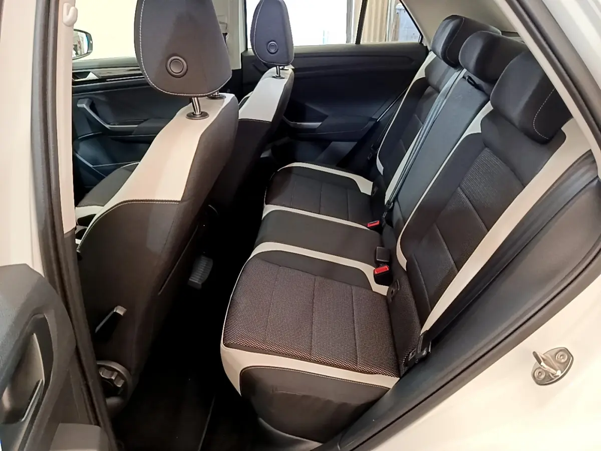 Vue intérieure côté droit sur la banquette arrière bicolore noire et beige du Volkswagen T-Roc blanc 2020.